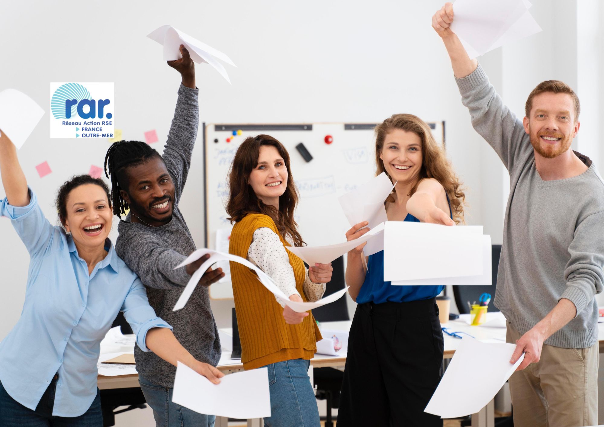 Sensibilisation RSE avec des hommes et femmes dans un bureau qui lèvent les bras et jettent des feuilles blanches